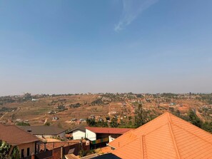 A residential area with houses and a hilly landscape in the background. - Muyange Heights The Residence (Kigali)