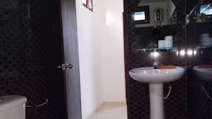 Un baño con inodoro, lavamanos y espejo.