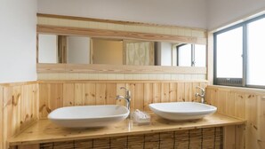 Une salle de bain avec deux lavabos, un miroir et une fenêtre.