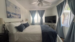 A bedroom with a bed, a ceiling fan, a TV, and curtains. - Kayaks, Bikes, Beach, Pennekamp 1 mile, walk to restaurants & shops (Key Largo)