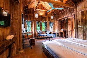 Una habitación rústica de madera con una cama, un escritorio y una zona de estar.