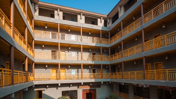 Un immeuble à plusieurs étages doté de balcons et d’une cour intérieure.