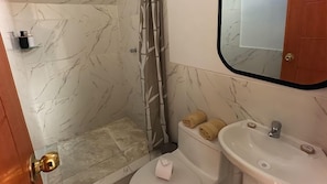 A bathroom with a shower, toilet, and sink.