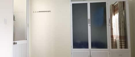 A room with a bed, a wardrobe, and a door.
