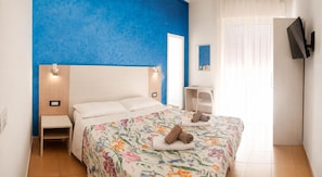 A hotel room with a bed, bedside table, and a TV mounted on the wall. - Hotel Villa Panda (Rimini)