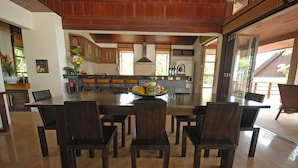 A spacious dining area with a large island and dark wooden chairs. - BKE Villa (Koh Samui)