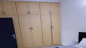 Ein Schlafzimmer mit einem Bett, einem Kleiderschrank und einer Tür.