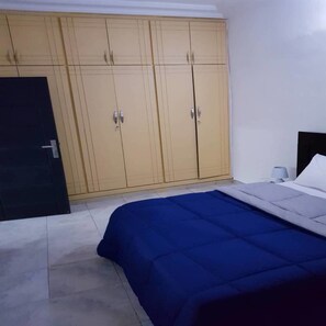 Une chambre à coucher avec un lit, une armoire et une porte.
