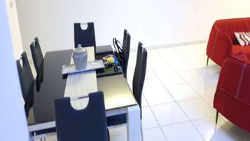 Un comedor con una mesa, sillas y un cuadro en la pared.