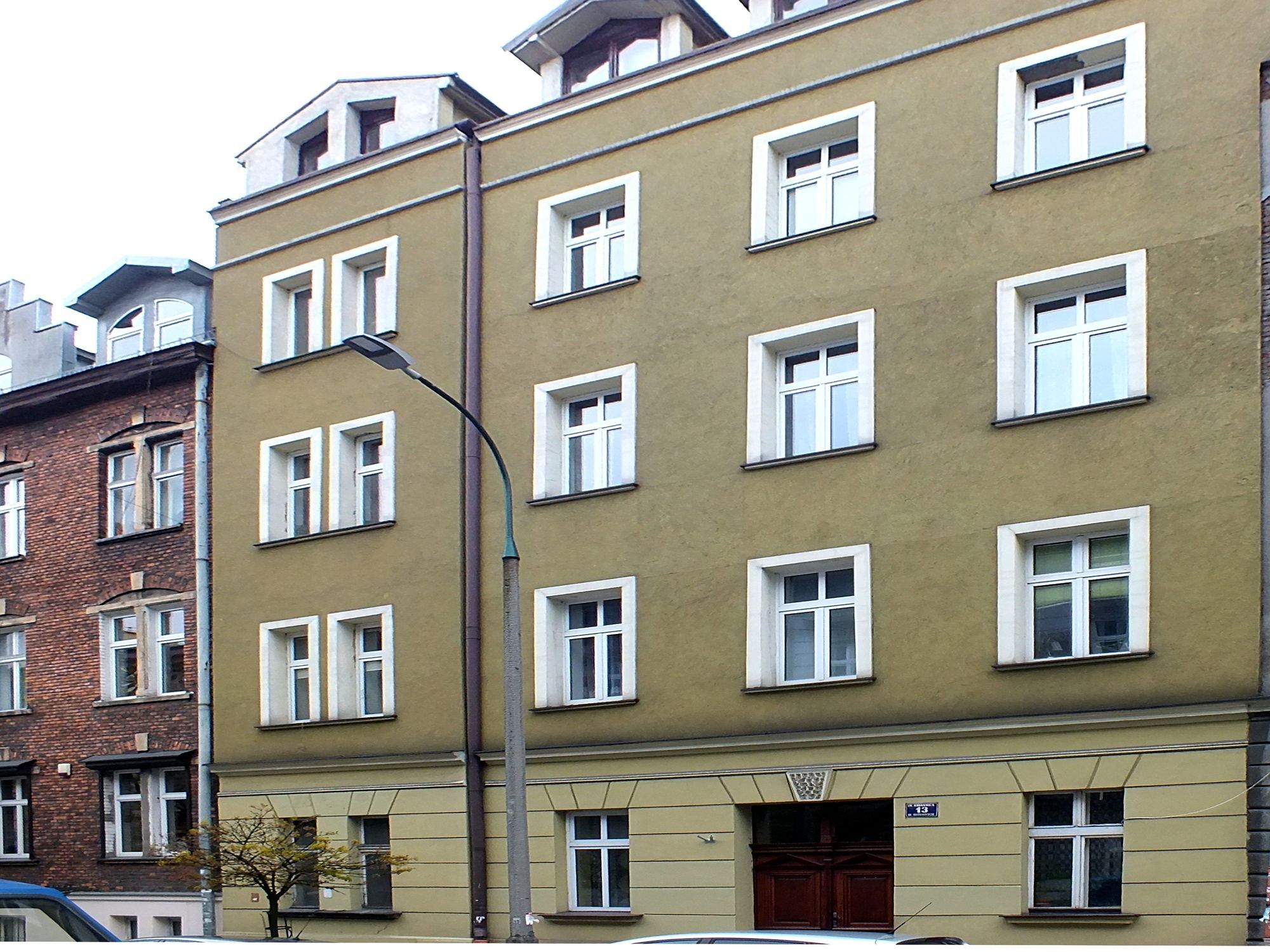 A multi-story building with a consistent window pattern and a central entrance with a door.