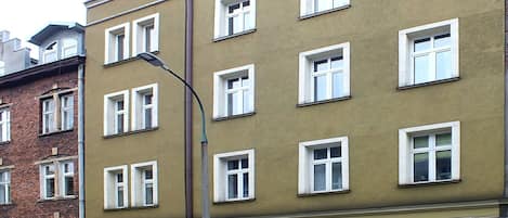 A multi-story building with a consistent window pattern and a central entrance with a door.