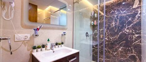 Une salle de bain moderne avec une douche à parois de verre, un meuble-lavabo et un miroir.