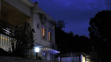 Un edificio di due piani con un balcone e una scala che vi conduce.
