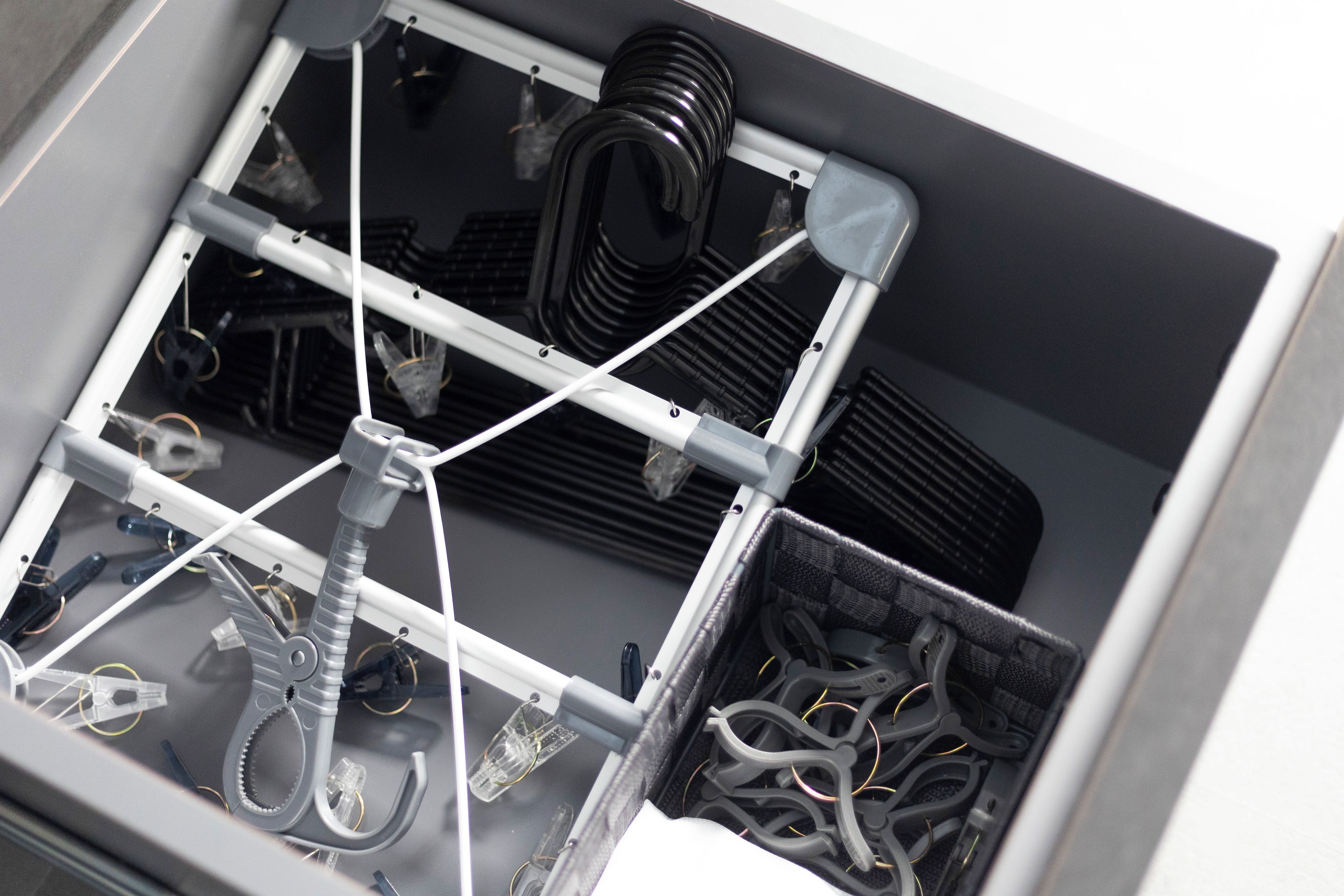 Un compartimento de almacenamiento con varios objetos, como cables, una bicicleta y un par de tijeras.