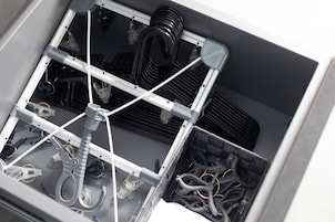 Un compartimento de almacenamiento con varios objetos, como cables, una bicicleta y un par de tijeras.