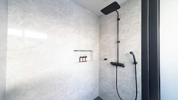 A modern shower with a handheld showerhead and a wall-mounted control panel.