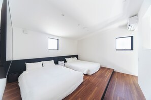 A hotel room with two beds, a wooden floor, and a small window. - Villa mirai (Oshima-gun Setouchi-cho)