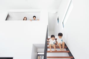 Un interior moderno con una escalera, un ventanal pequeño y una puerta.