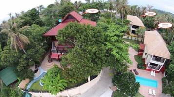A resort with multiple villas, a swimming pool, and a waterfall.