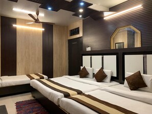 Quarto de hotel com duas camas, um ventilador de teto e um espelho grande.