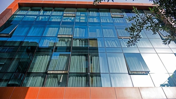 Un edificio moderno con fachada de vidrio y techo rojo.