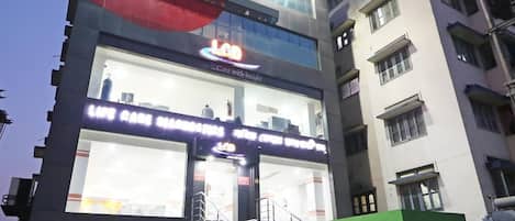 A multi-story building with a large illuminated sign for a medical diagnostics center.