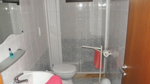 A bathroom with a white sink, a toilet, and a shower area. - Bluesky Alloggi (Melendugno)