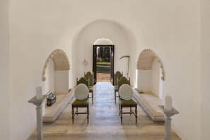 A corridor with a bench seating arrangement, leading to an open area.