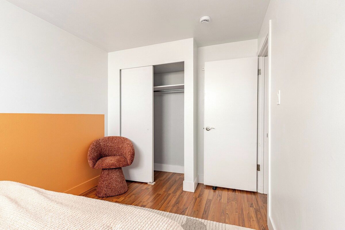 A bedroom with a bed, a closet, and a unique chair.