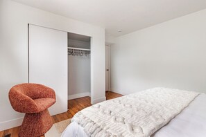 Une chambre à coucher avec un lit, une chaise et une armoire.
