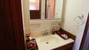A bathroom with a white sink, a mirror, and a towel ring. - Cottage Hakuraku (Onna)