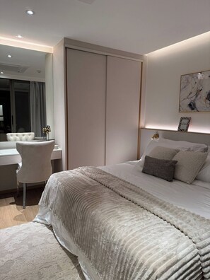 Ein modernes Schlafzimmer mit einem großen Bett, einem Schreibtisch und einem Stuhl.