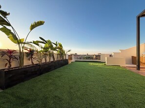 A rooftop garden with artificial grass, potted plants, and a seating area. - Private Jacuzzi Escape  Romantic & Luxurious (Cairo Governorate)