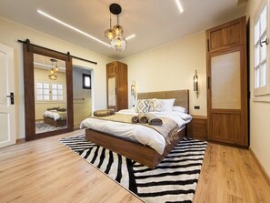 A bedroom with a large bed, wooden wardrobe, and a mirror. - Private Jacuzzi Escape  Romantic & Luxurious (Cairo Governorate)