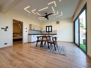 A modern kitchen with a dining area, wooden flooring, and a ceiling fan. - Private Jacuzzi Escape  Romantic & Luxurious (Cairo Governorate)