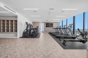 A gym with treadmills, stationary bikes, and a mirrored wall. - CASSA CASINO TOWER 2 - Brand New Premium Residence Managed by The Cassa (Broadbeach)