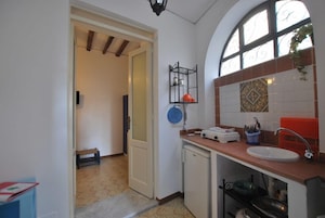 Una cocina con lavamanos, encimera y ventana con azulejos decorativos.
