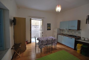 Una cocina compacta con una mesa de comedor, sillas y una pequeña isla.