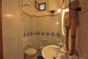 Un baño con inodoro, lavabo y ducha.