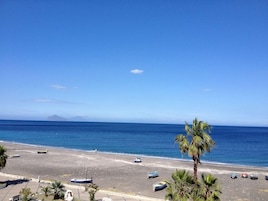 Una playa con barcos, palmeras y cielo despejado.