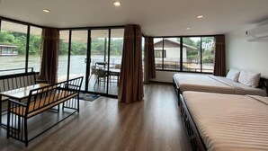 A room with a large window, a bed, a table, and a chair. - Goodview Resort & Camping (Sai Yok)