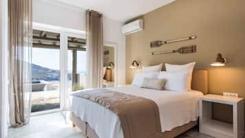 Ein Schlafzimmer mit Bett, Nachttischen, einer Klimaanlage und Blick ins Freie.