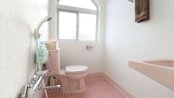 A bathroom with a toilet, a shower, and a sink.