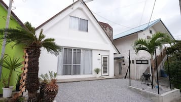 A two-story building with a white facade, a visible garage door, and a sign indicating 'CINEMA RESORTS.'