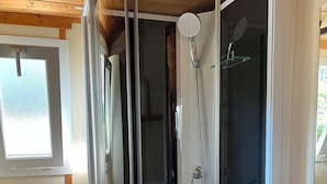 A modern bathroom with a glass-enclosed shower, a wooden ceiling, and a built-in sink. - Grand Bleu Cottage Les Pescalunes (Agde)