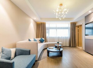 A modern living room with a sofa, a coffee table, and a TV. - Atour Hotel (Hangzhou)