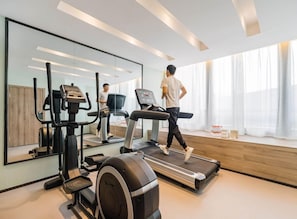 A modern gym with a treadmill, elliptical, and stationary bike. - Atour Hotel (Hangzhou)