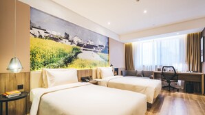 Una habitación de hotel con dos camas, un escritorio, una silla, una lámpara y un cuadro grande en la pared.