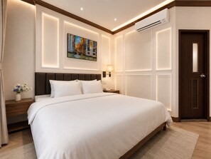 Een hotelkamer met een groot bed, een schilderij aan de muur, een bedlamp en een airconditioning.