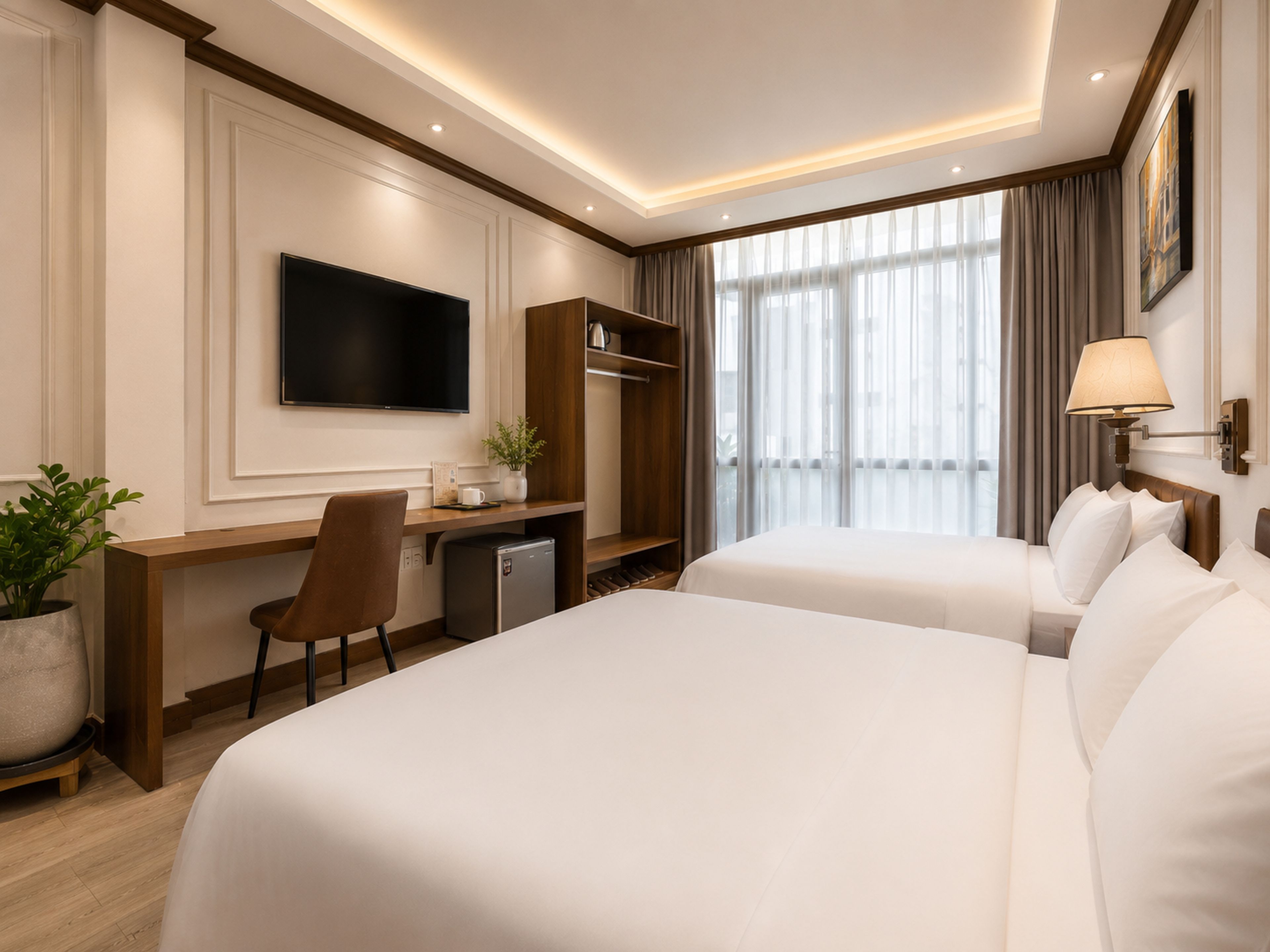 A hotel room with two beds, a desk, a television, and a large window with curtains.